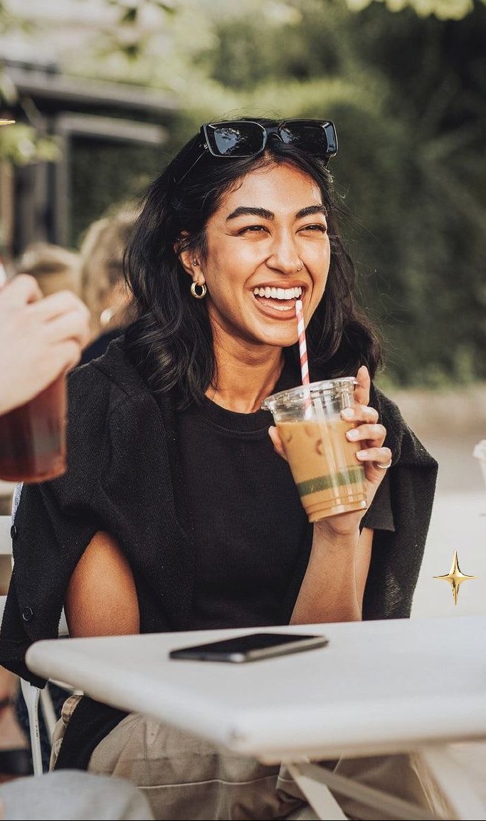 A guest laughing with an iced coffee